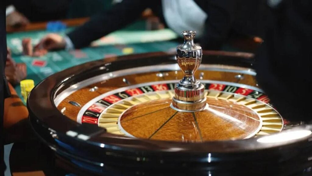 A detailed close-up of a polished wooden roulette wheel on a casino gaming table.