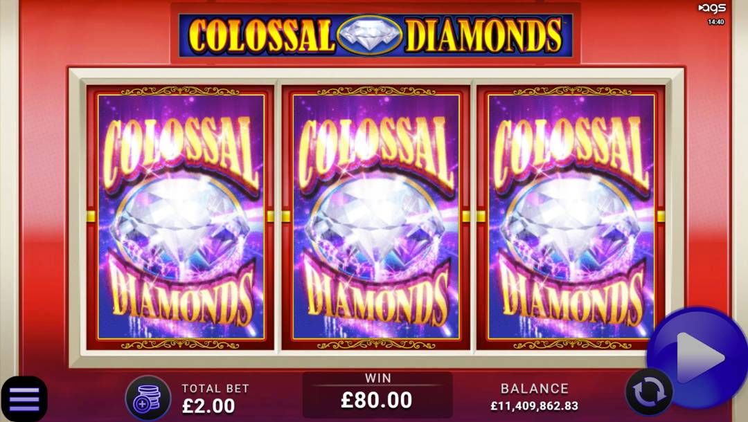 A screenshot of the reels in Colossal Diamonds. The game’s background is a simple red slot machine with the game’s title. Three Colossal Diamonds symbols are displayed on the reels.