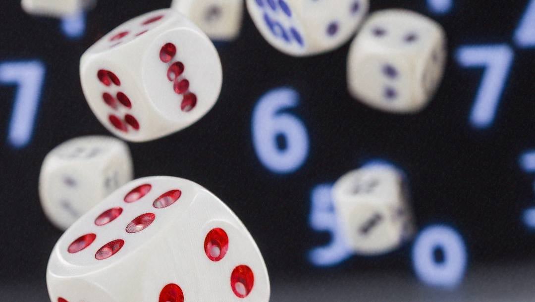 Falling dice against a black background with random numbers in blue.