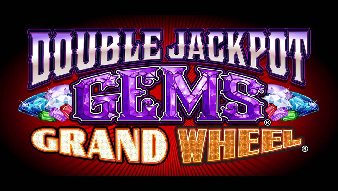 The Double Jackpot Gems Grand Wheel title screen. The background features red with black lines pointing outwards. The game title appears in a variety of different font styles with gems visible next to the word “Gems”.