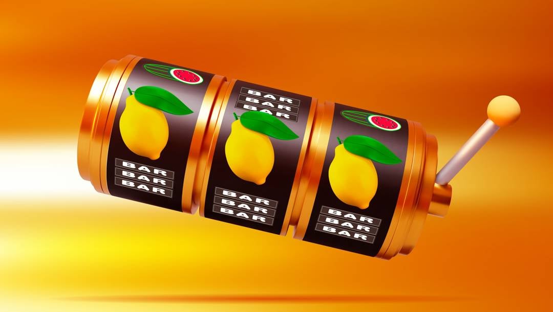A slot machine slot reel with three lemons on it against a gold background.