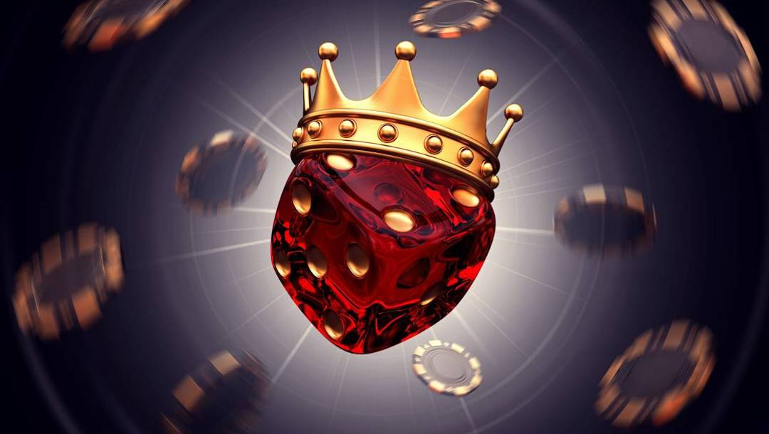 A glowing, translucent red die wearing a golden crown is suspended among blurred casino chips floating against a dark background.