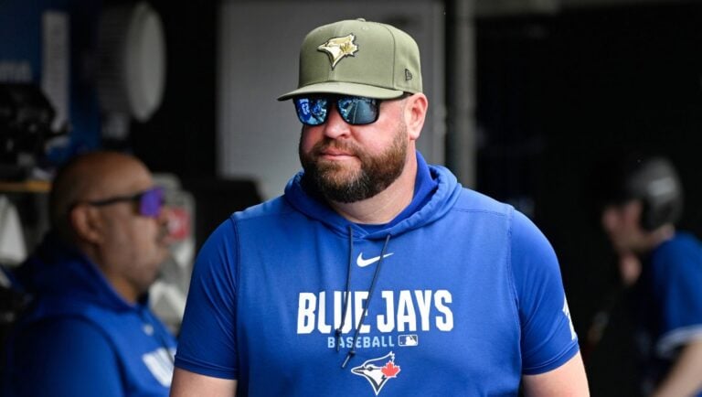 Toronto Blue Jays manager John Schneider walks in the dugout during the third inning of a baseball game against the Detroit Tigers, Saturday, May 16, 2026, in Detroit.