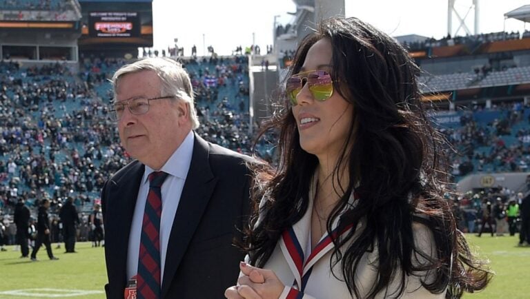 In this Jan. 7, 2018, file photo, Buffalo Bills owners Terry Pegula, center, and Kim Pegula, right, walk on the sideline during warmups before an NFL wild-card playoff football game against the Jacksonville Jaguars in Jacksonville, Fla.