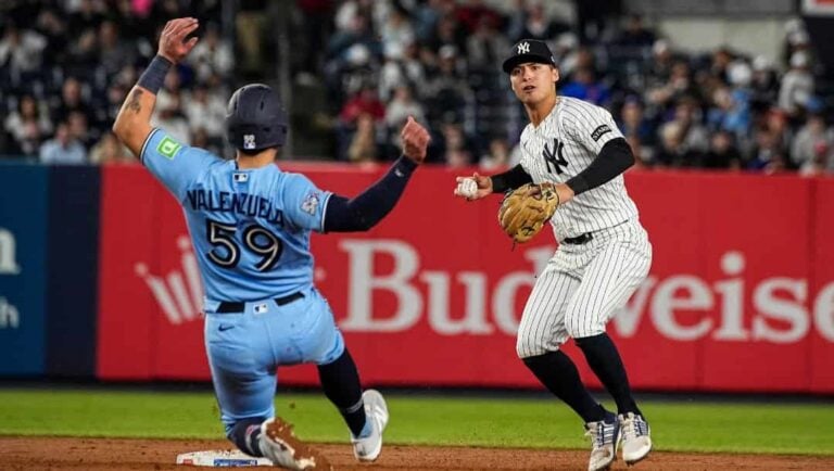 New York Yankees shortstop Anthony Volpe, right, throws to first base after forcing Toronto Blue Jays Brandon Valenzuela (59) out at second base on a double play, during the ninth inning of a baseball game, Thursday, May 21, 2026. in New York