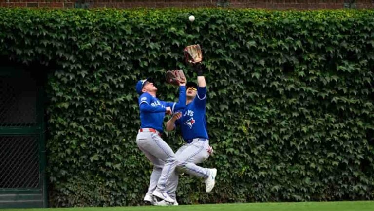 Toronto Blue Jays right fielder Myles Straw, left, and center fielder Dulton Varsho collide as Varsho' makes the catch on a fly ball hit by Chicago Cubs' Miguel Amaya during the fourth inning of a baseball game, Saturday, June 20, 2026, in Chicago.